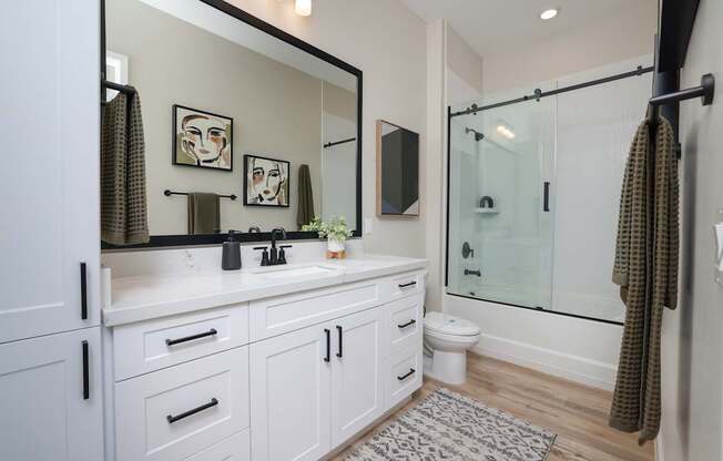 A bathroom with a white cabinet and a mirror above the sink.