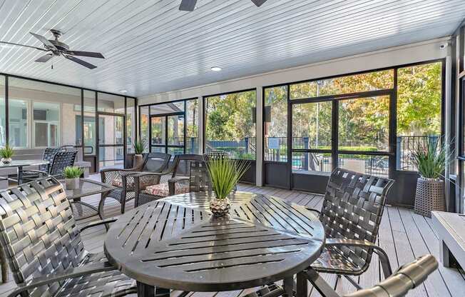 Greentree Apartments in Savannah, GA photo of a screened in porch with a table and chairs