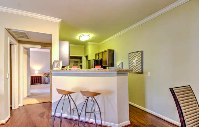 a living room with a bar with three stools