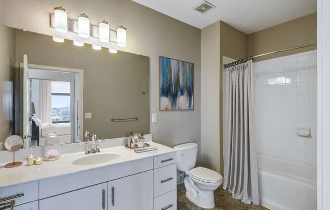bathroom with white vanity and tub shower