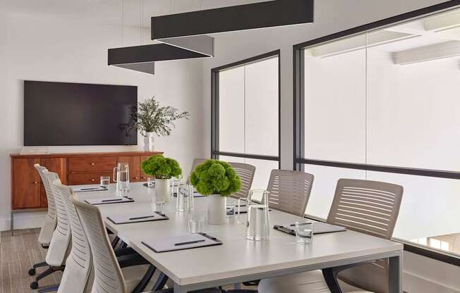 A conference room with a long table and chairs.