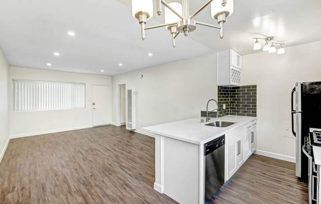 an open kitchen and living room with a white counter top