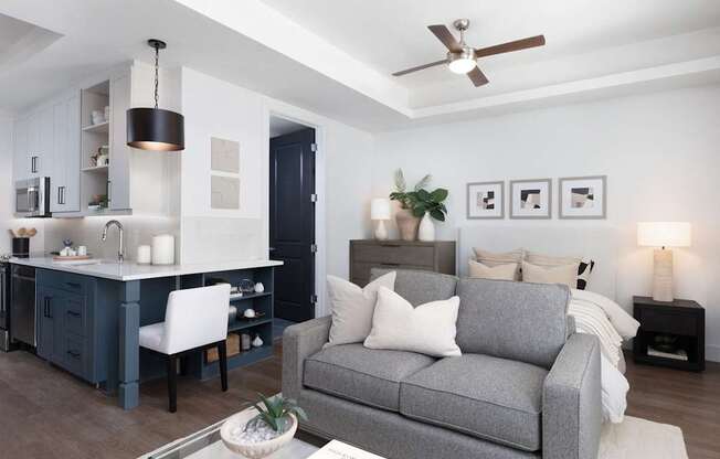 A modern living room with a grey couch and a glass coffee table.