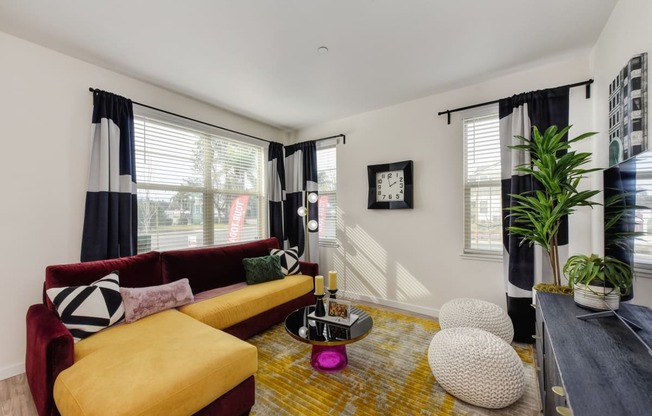 Living Room with Hardwood Inspired Flooring with Red and Yellow Couches at Morgan Ranch Apartments, Morgan Hill, CA, 95037