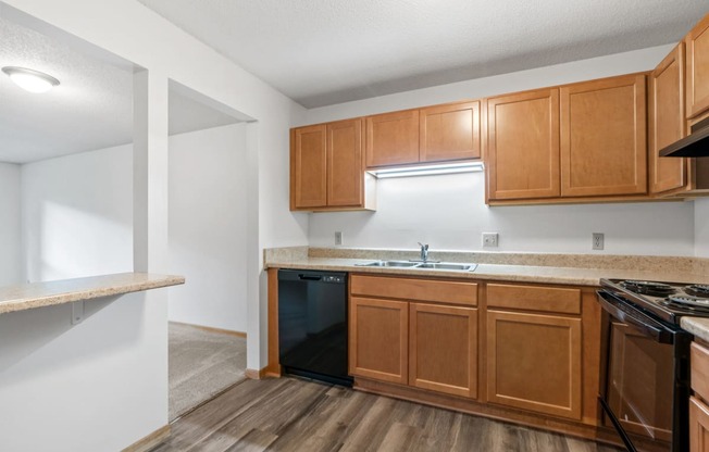 an empty kitchen with wooden cabinets and a stove and sink