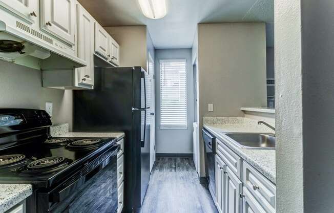 Empty kitchen with black appliances and white cabinets  at Union Heights Apartments, Colorado Springs, CO