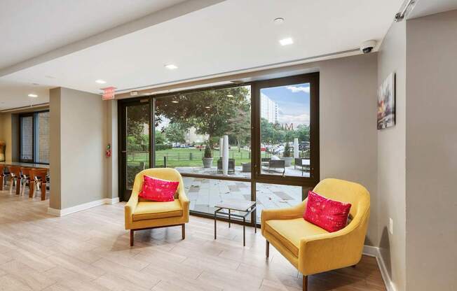 Two yellow chairs with red pillows in clubroom at The Graham at Southern Towers, Alexandria, 22311