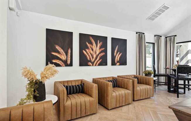 A living room with brown sofas and a painting of a plant.