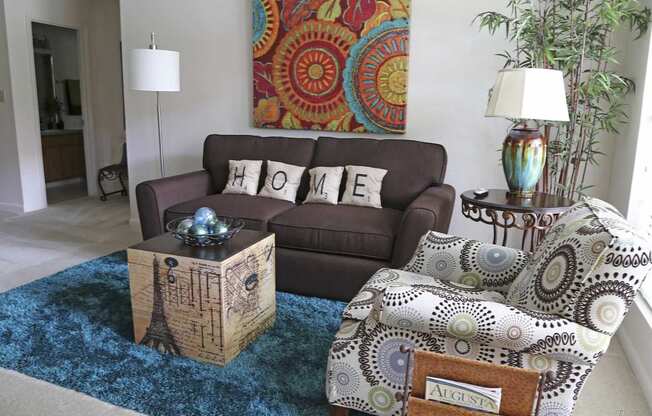 a living room with a brown couch and a rug