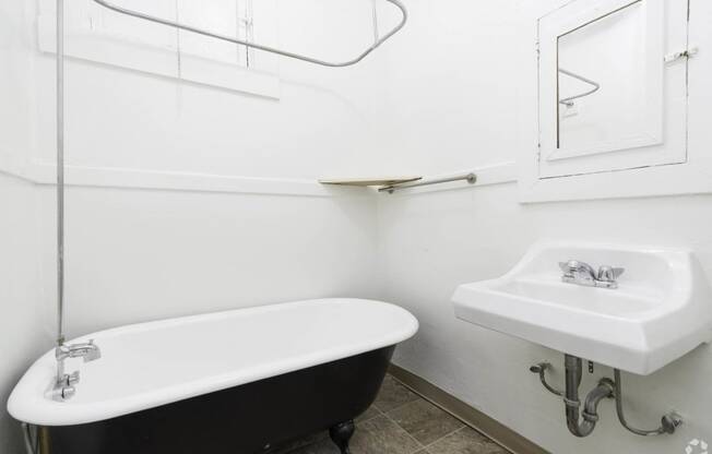 a white bathroom with a black bath tub and a sink at Clay & Tiffany, Portland, OR
