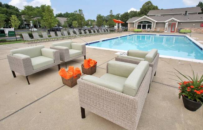 a swimming pool with chaise lounge chairs and potted plants