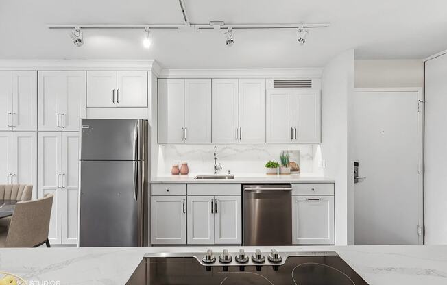 a kitchen with white cabinets and a stainless steel refrigerator