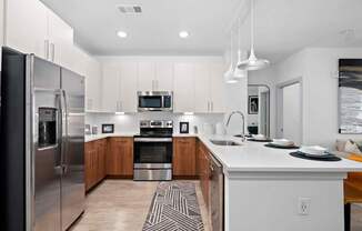 A modern kitchen with a refrigerator, oven, and sink.