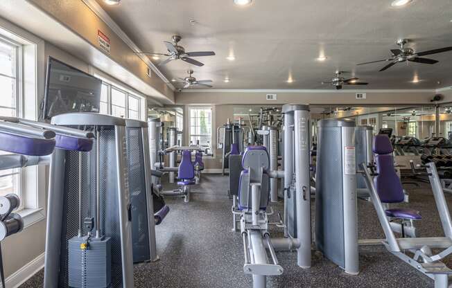 a fitness room with cardio equipment and weights