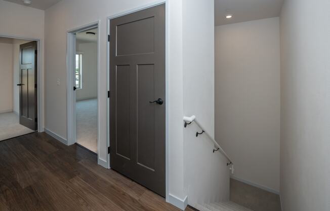 a door is open to a hallway with a staircase and a door to a bedroom at The Crossings at Windsong, Prescott Valley, AZ
