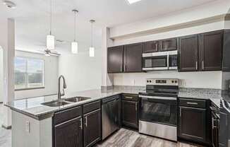 Pet-Friendly Rentals in Bentonville, AR – Parc at Bentonville – A kitchen with black cabinets and stainless steel appliances.