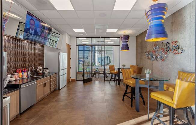 a dining area with a table and chairs and a television on the wall