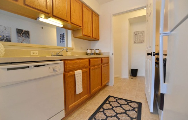 a kitchen with wooden cabinets and a white dishwasher