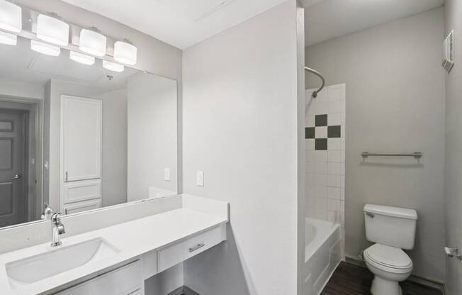 A white bathroom with a toilet, sink, and bathtub.