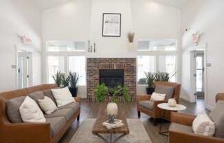 a living room with white walls and a brick fireplace