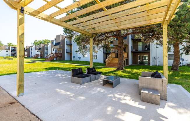 a patio with chairs and a wooden pergola