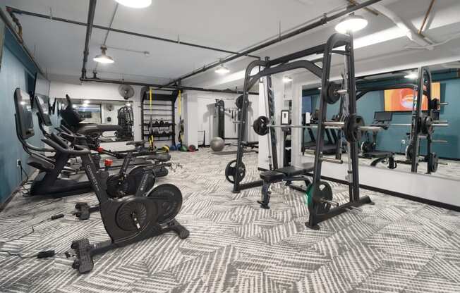 a spacious fitness room with cardio machines and weights
