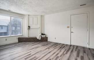 an empty living room with a window and a door