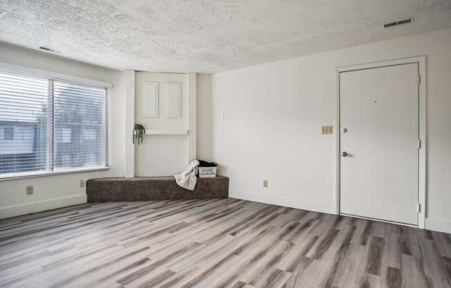 an empty living room with a window and a door