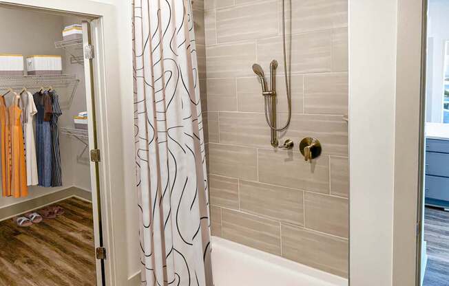 A bathroom with a shower curtain and a white bathtub.