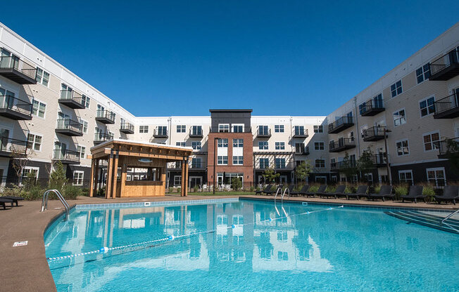 A swimming pool in front of apartment buildings.