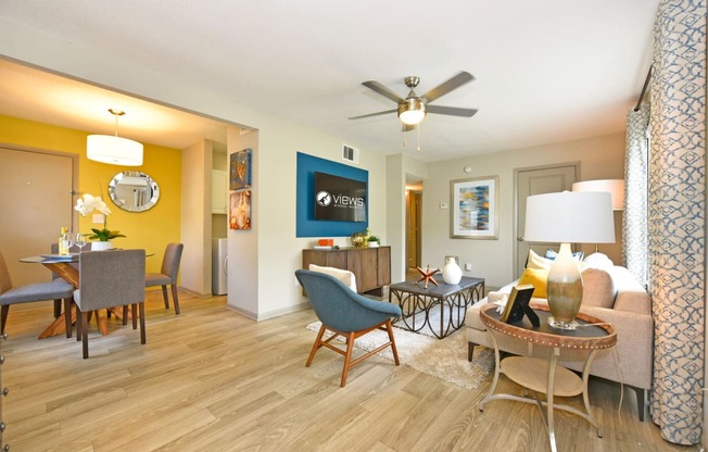 a living room with a ceiling fan and hardwood flooring