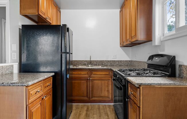 a kitchen with black appliances and wooden cabinets