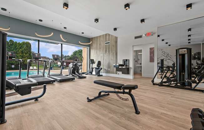 A gym with treadmills, weights, and exercise equipment.