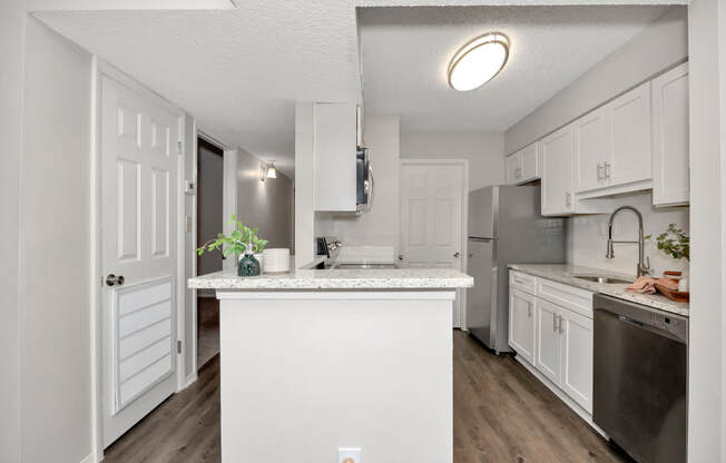 A kitchen with white cabinets and a white island.