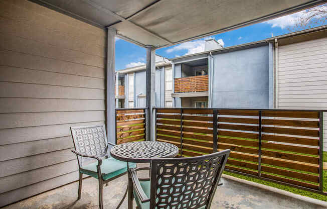 a patio with chairs and a table with a basket on top of it