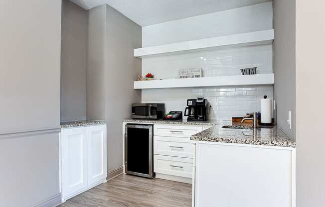 a kitchen with white cabinets and counter tops and a sink