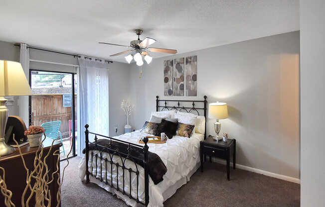 spacious bedroom with ceiling fan and large window