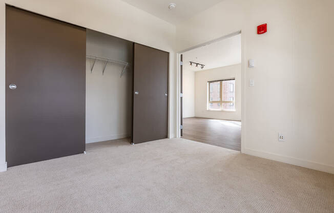 A room with a carpeted floor and a door on the left.