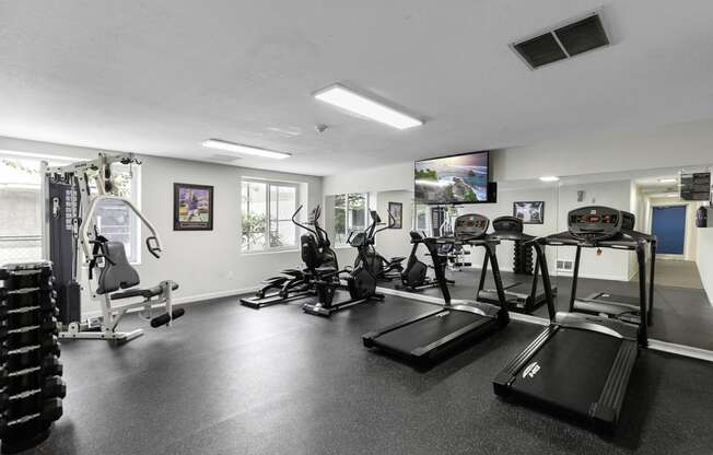 a gym with cardio equipment and a flat screen tv at Willows Court Apartment Homes, Washington, 98125