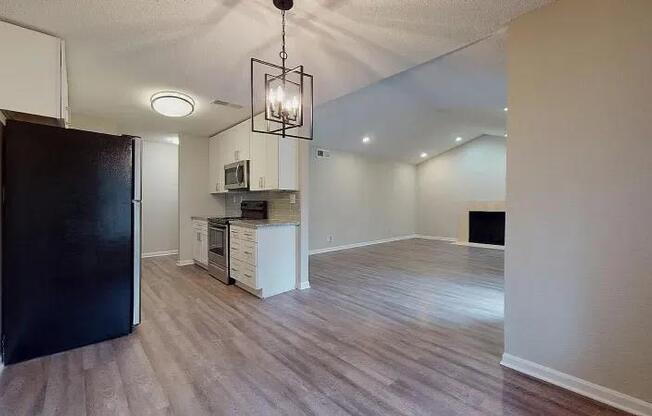 A kitchen area with a black refrigerator and a wooden floor. at Spalding Vue, Peachtree Corners, 30092