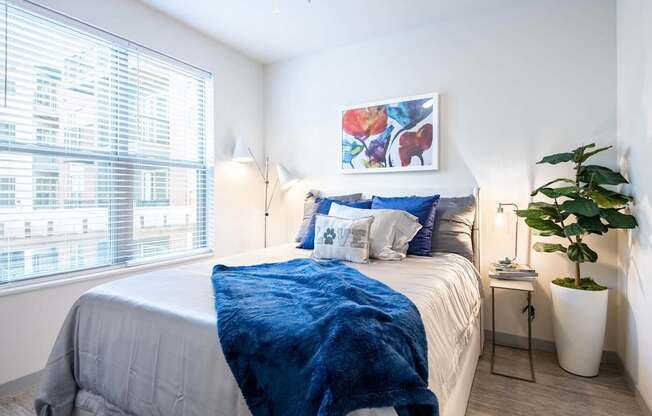 A bedroom with a large bed and a painting on the wall.