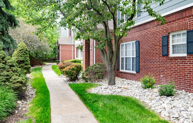 A tree in front of a red brick house.