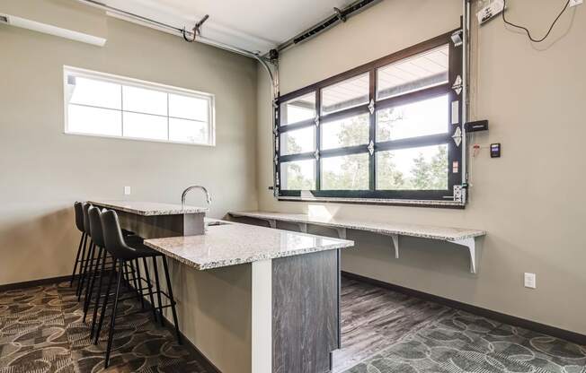 Community room with a bar height counter top and seating plus a window