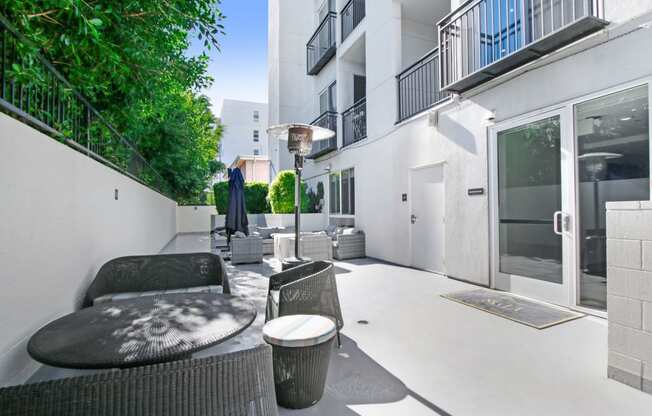 a patio with a table and chairs in front of a building