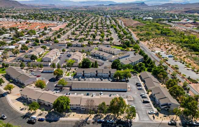 an aerial view of a neighborhood of houses and cars in a parking lot