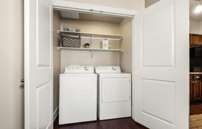 a laundry room with a washer and dryer and a closet with shelves