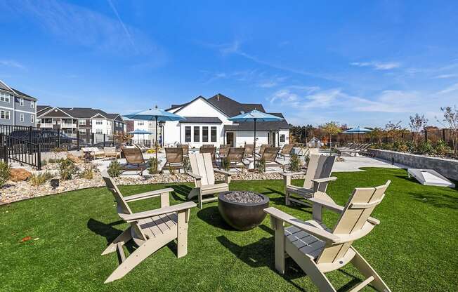 A backyard with a fire pit and chairs.