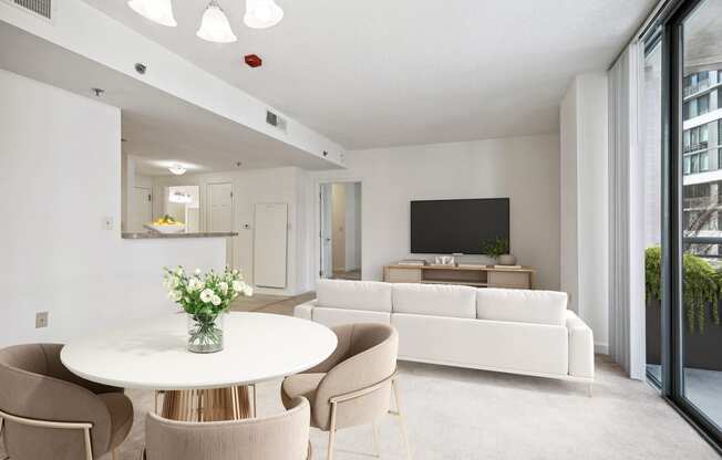 a living room with white furniture and a white table and chairs