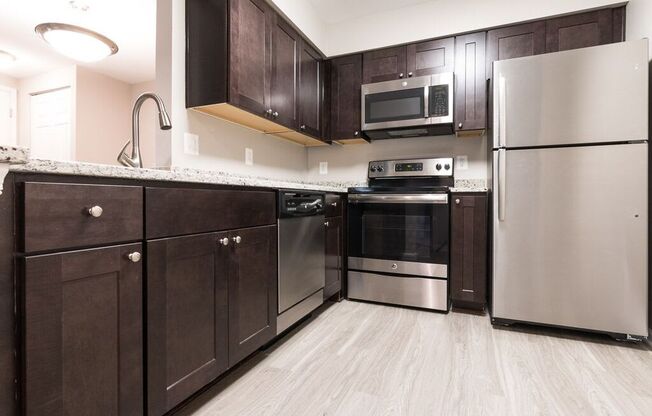 Kitchen with stainless steel appliances and granite countertops at Elme Manassas, Virginia