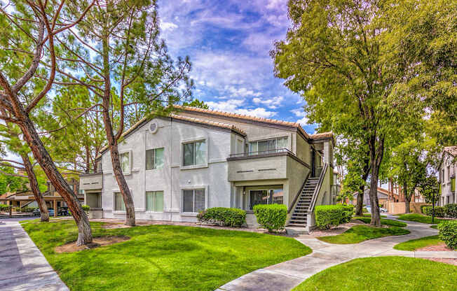 A modern two-story house with a white exterior and a large front yard.